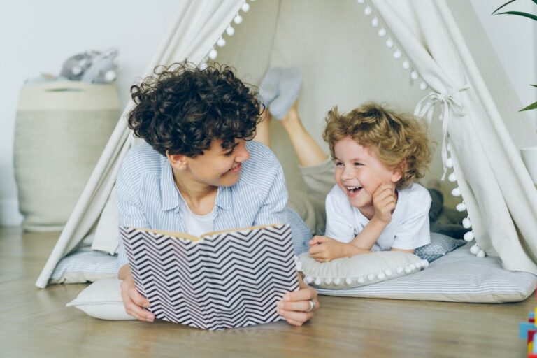 A parent reading with a laughing child, illustrating the beginner's guide to autism